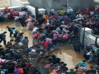 Yağmur yağınca okul bahçesi havuza döndü, öğrenciler tahta üzerinde yürüdü