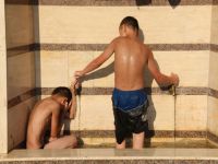 Sıcaklardan bunalan çocuklar, çeşme oluğunda serinlemeye çalıştı